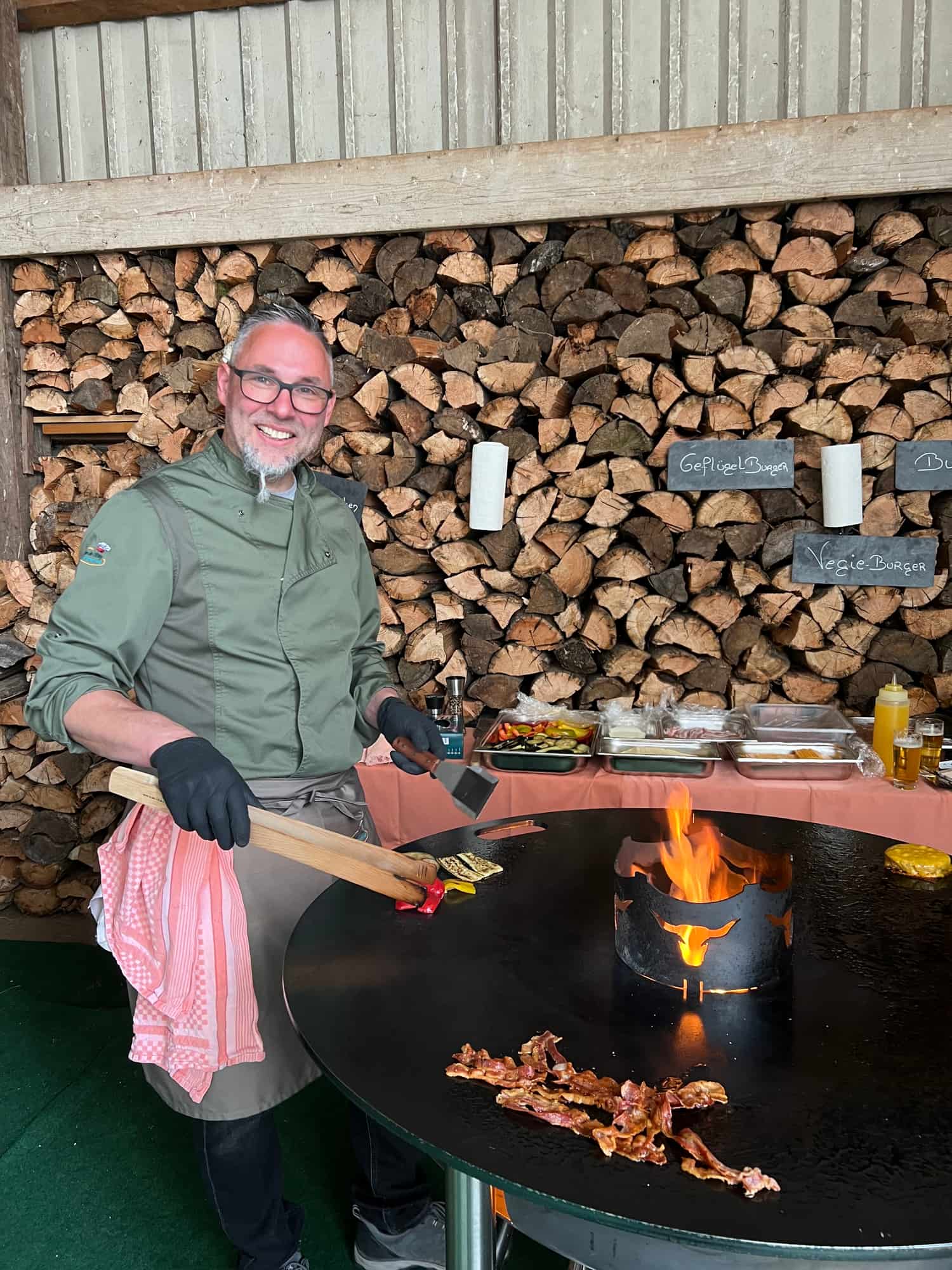 Chefkoch grillt an der Feuerplatte mit offenem Feuer bei einem Catering-Event